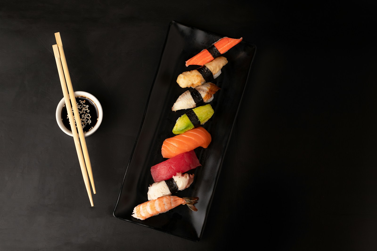 Tabla de sushi con rolls y palillos
